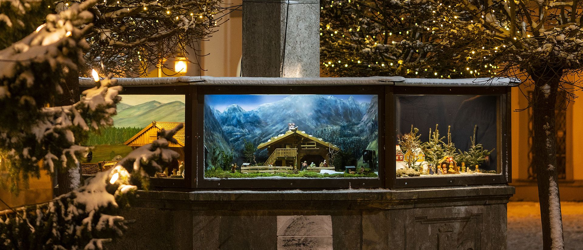 Beleuchtete Krippen am Diepoldbrunnen vor der Stiftsbasilika